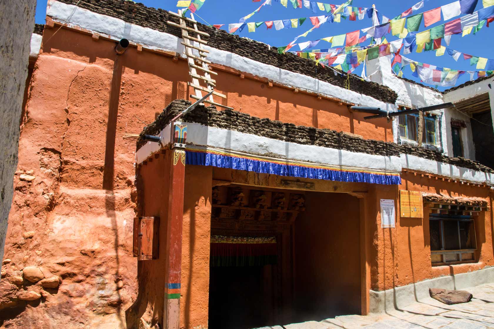 Восточный вход в монастырь Тубчен Гомпа в Ло-Мантанге, Верхний Мустанг, с молитвенными флагами и глинобитными стенами.
