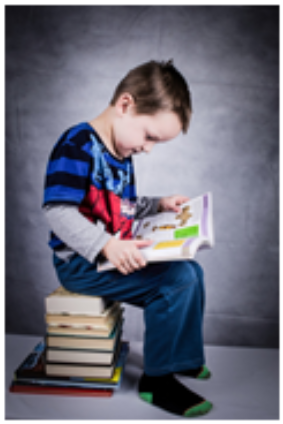 Фото 3. Описание | Мальчик сидит на книгах и читает книгу