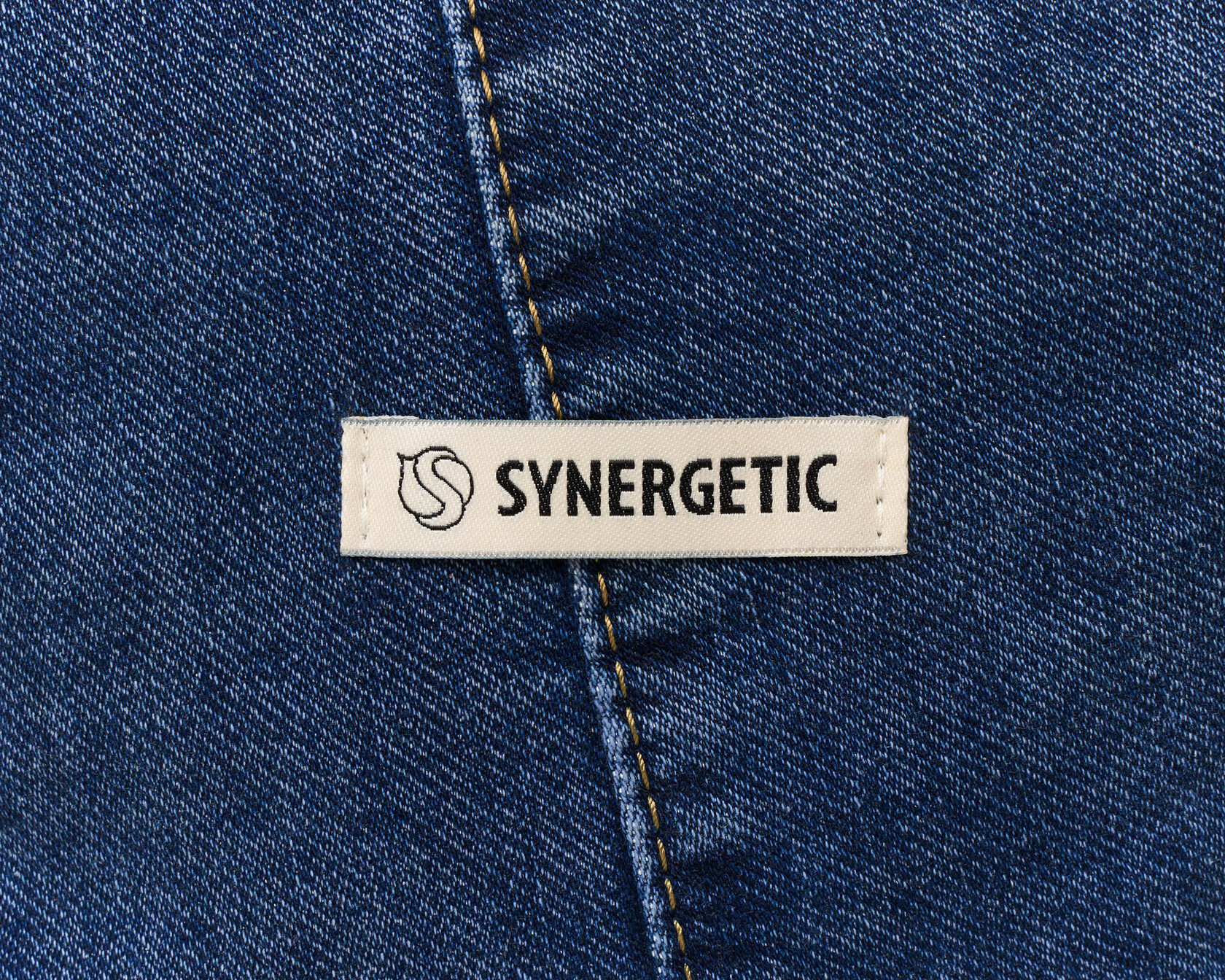 Шильда Synergetic на тёмной джинсе, деталь