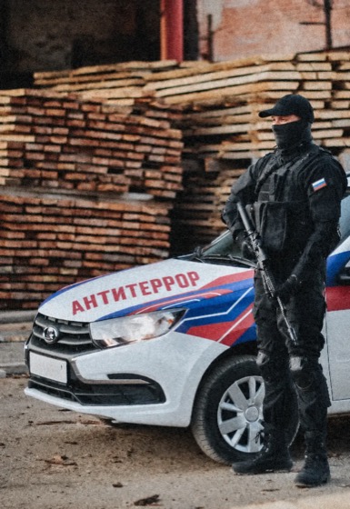 Сотрудник охраны АНТИТЕРРОР возле служебного автомобиля