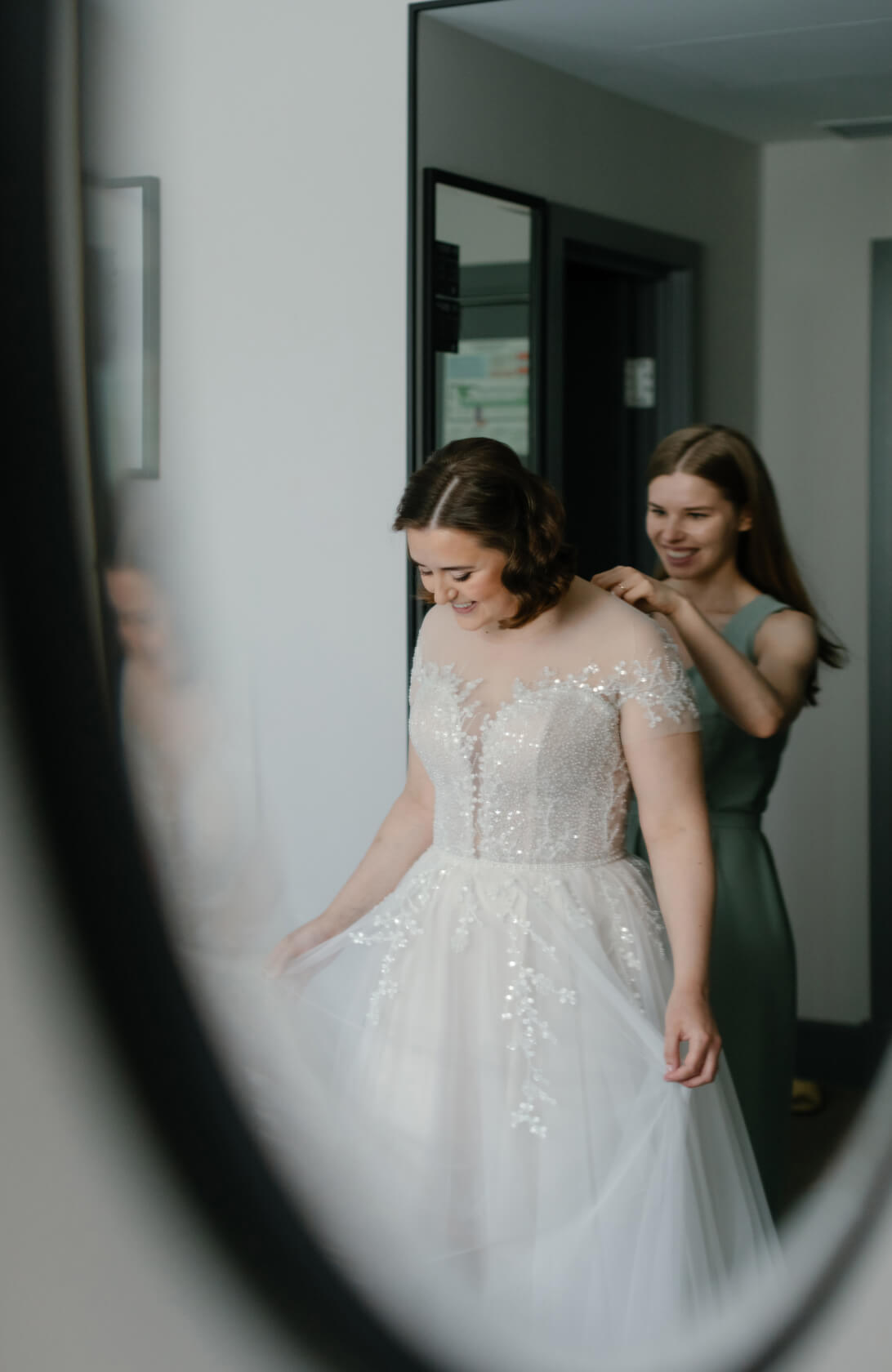 Стилист надевает платье на невесту