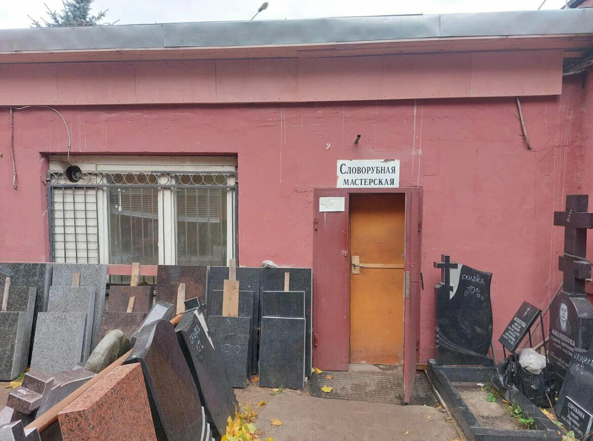 Вход в мастерскую на проспекте Стачек, 98Б: оранжевая дверь под вывеской «Словорубная мастерская»