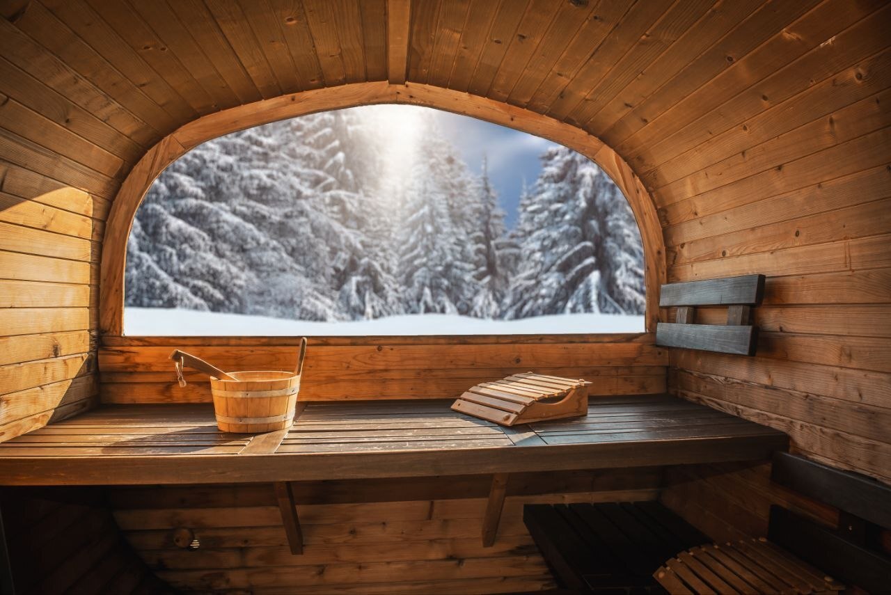 Faßsauna Innenraum mit Panoramafenster und Winterlandschaft