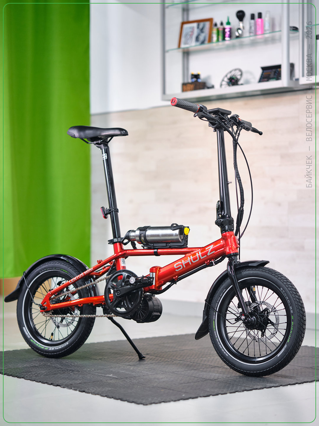 Красный складной велосипед Shulz Lentus Mini с кареточным электромотором в мастерской