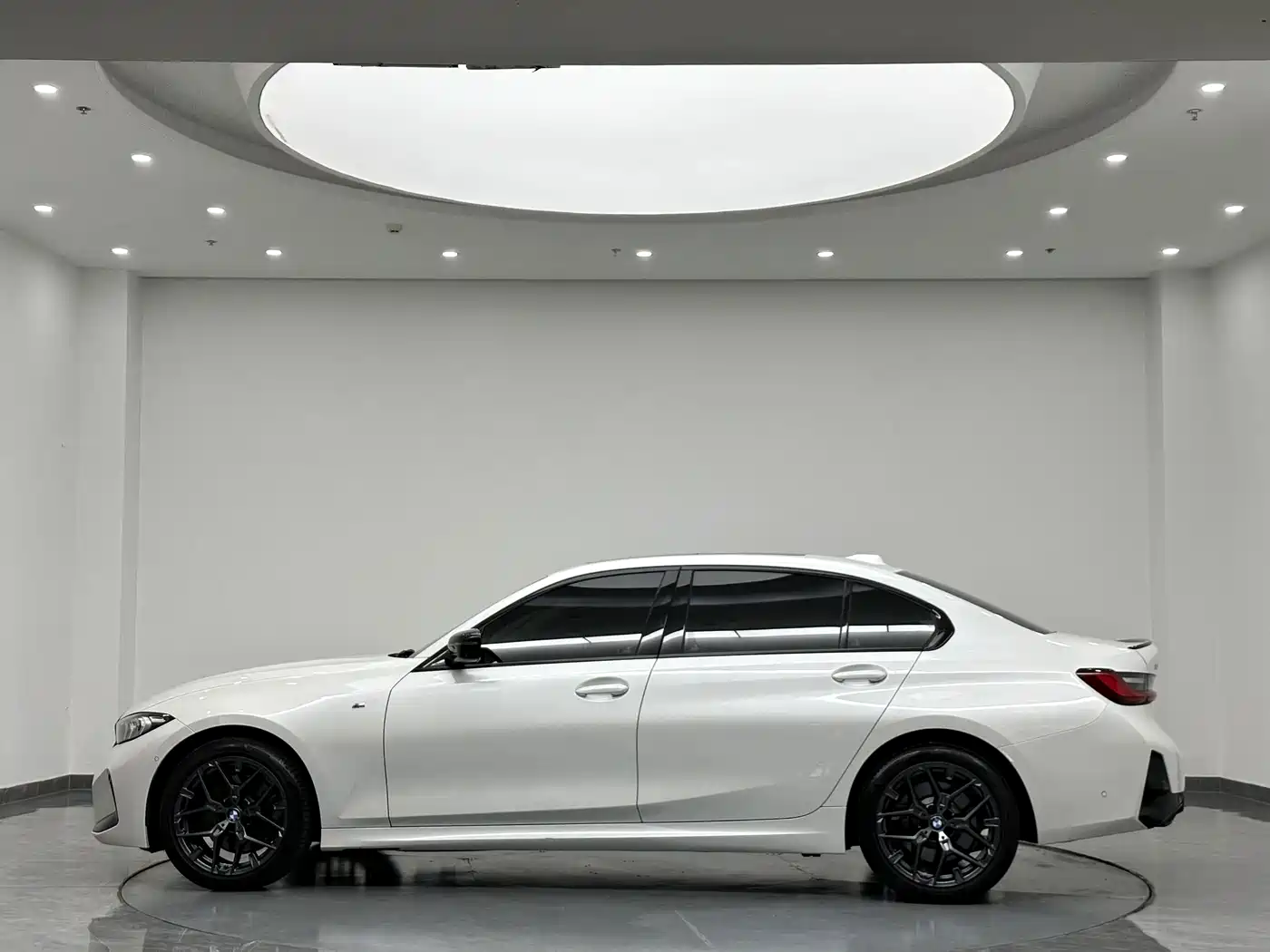 BMW 330Li G28 2024 M Sport Night Edition — белый седан с тёмными колёсными дисками, вид сбоку