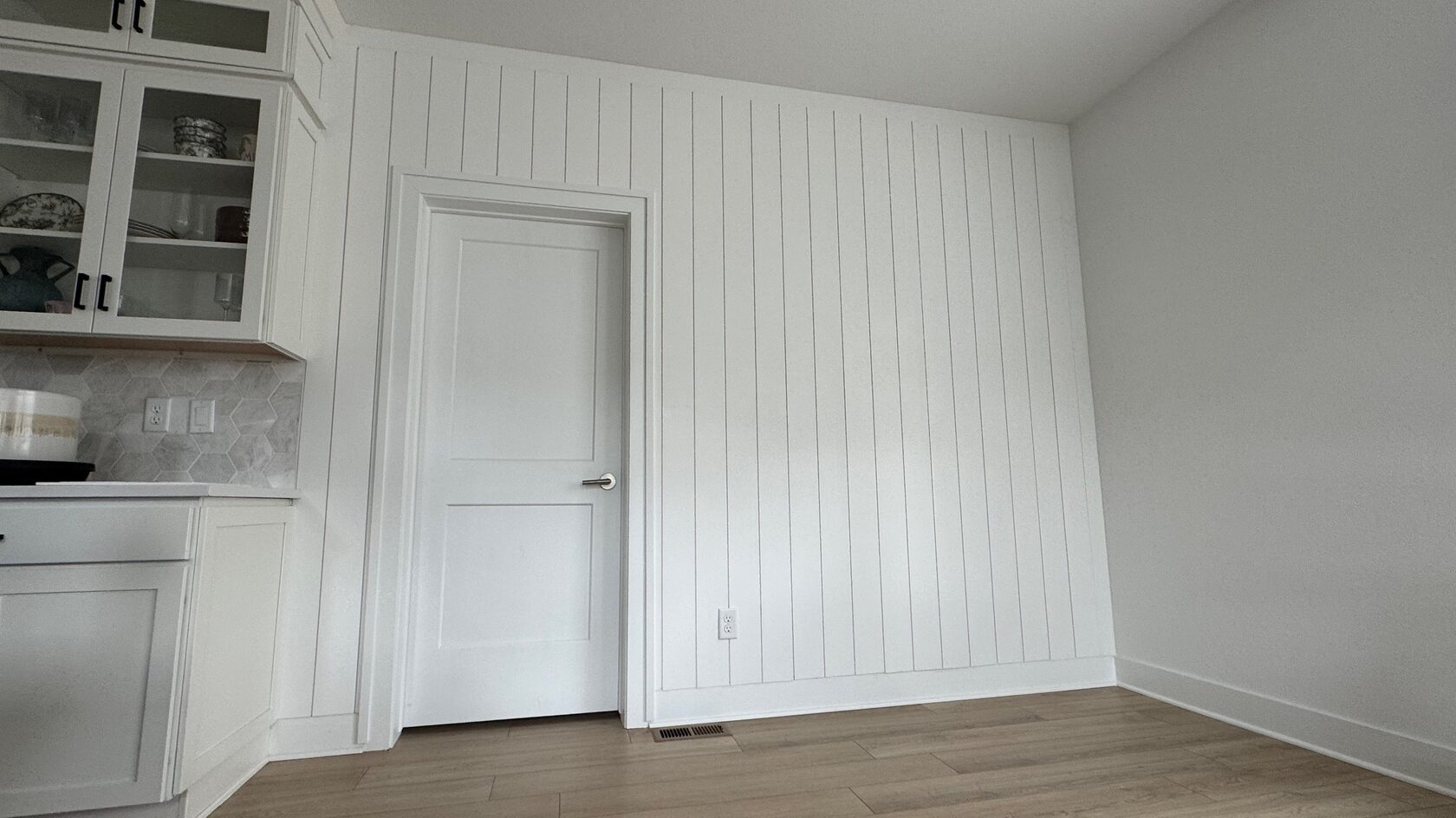 Wide view of the white shiplap wall connecting the kitchen and dining area.