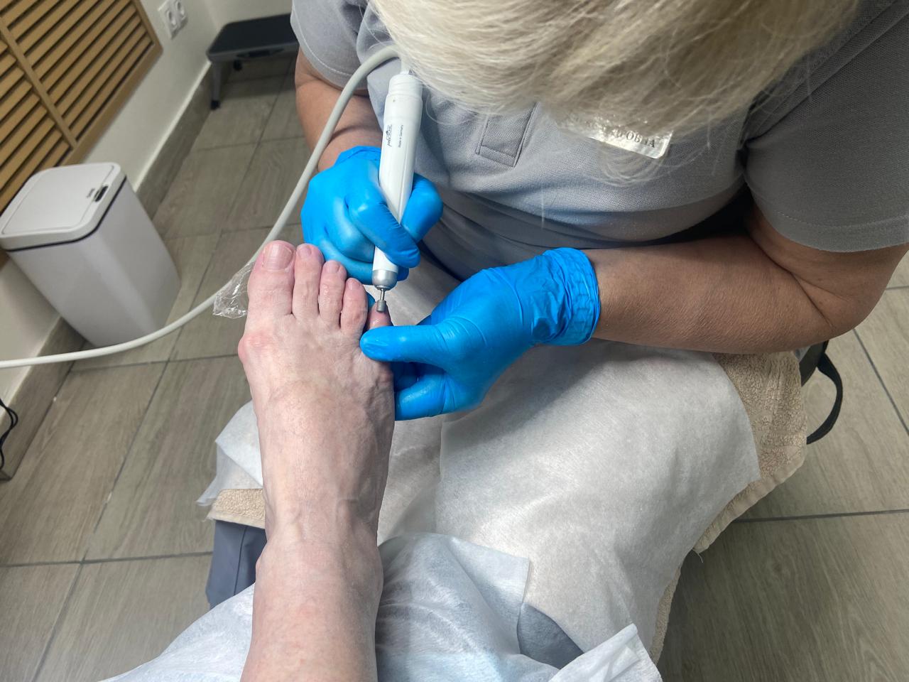 Подолог проводит дополнительную обработку ногтей