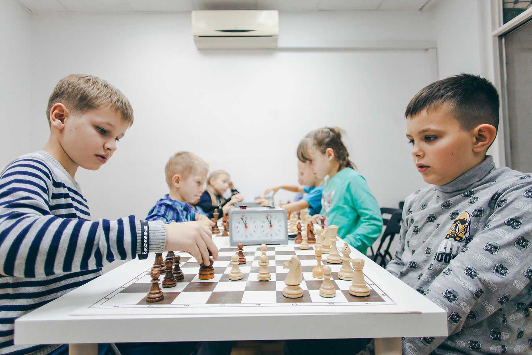 Ребёнок обдумывает ход на шахматной доске