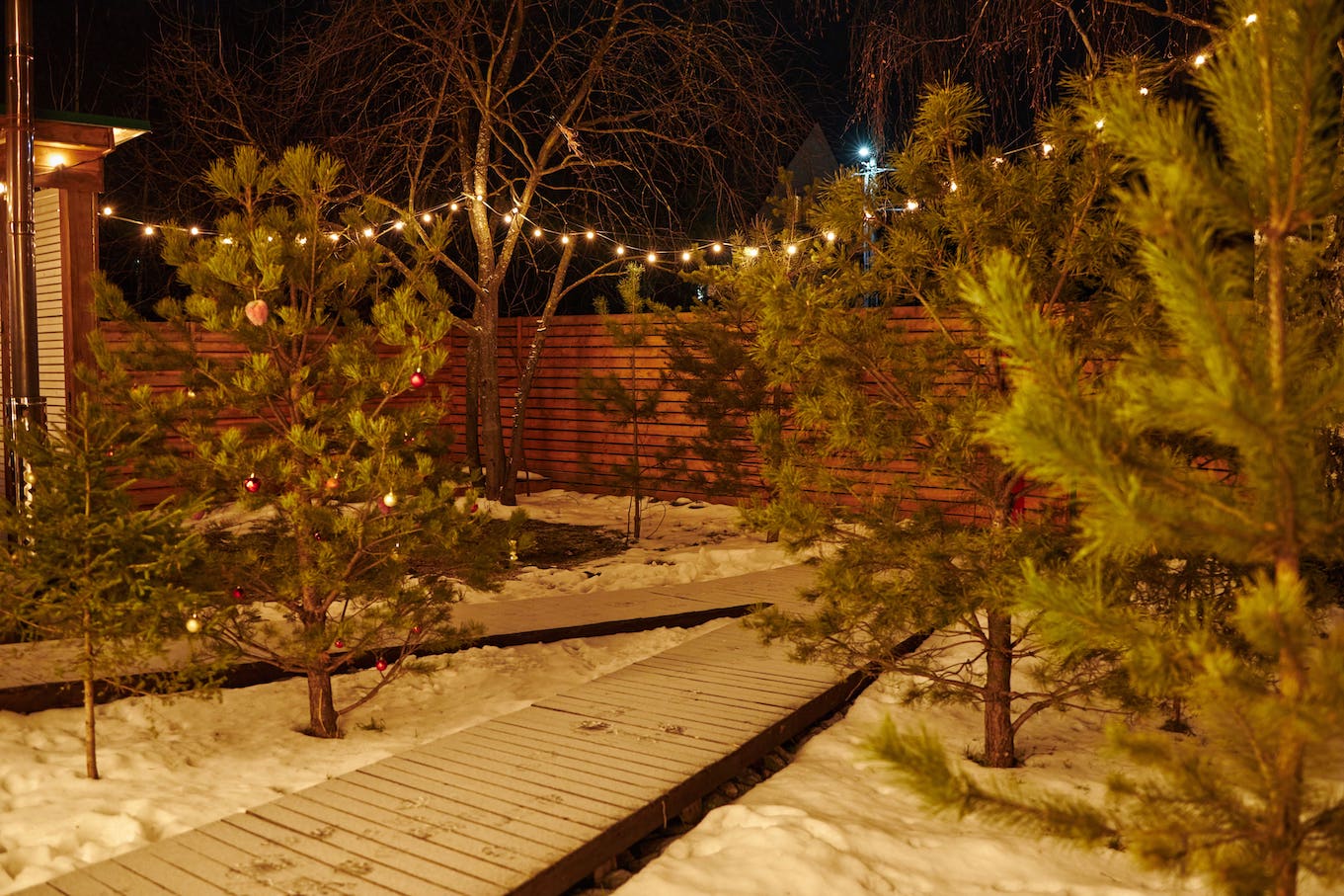 На заснеженной территории глэмпинга вечером при свете фонарей