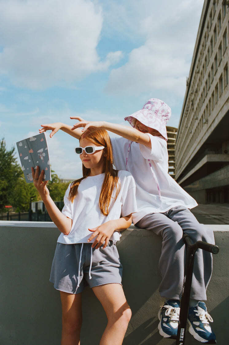 Девочка в хлопковых серых шортах и белой футболке