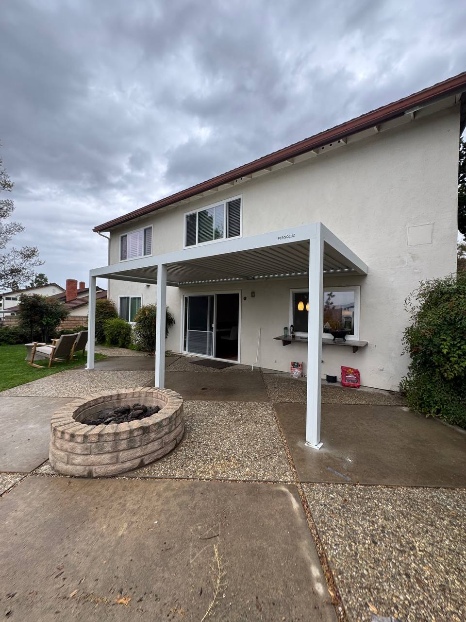 Wide angle of the completed white attached pergola extending from the home across a Fountain Valley backyard patio