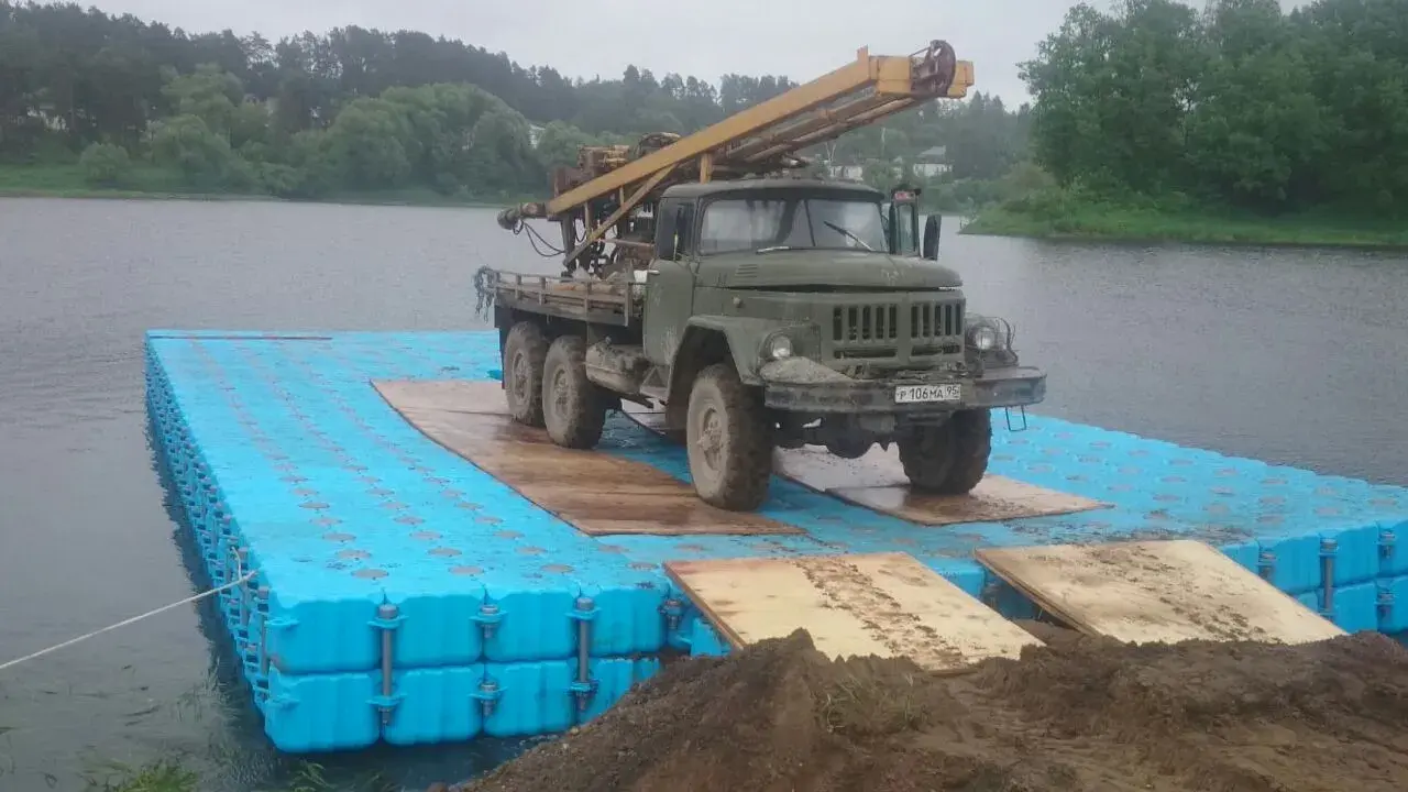 Военный грузовик заезжает на понтонную платформу