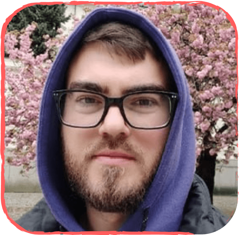 парень в капюшоне с бородой в очках на фоне сакуры