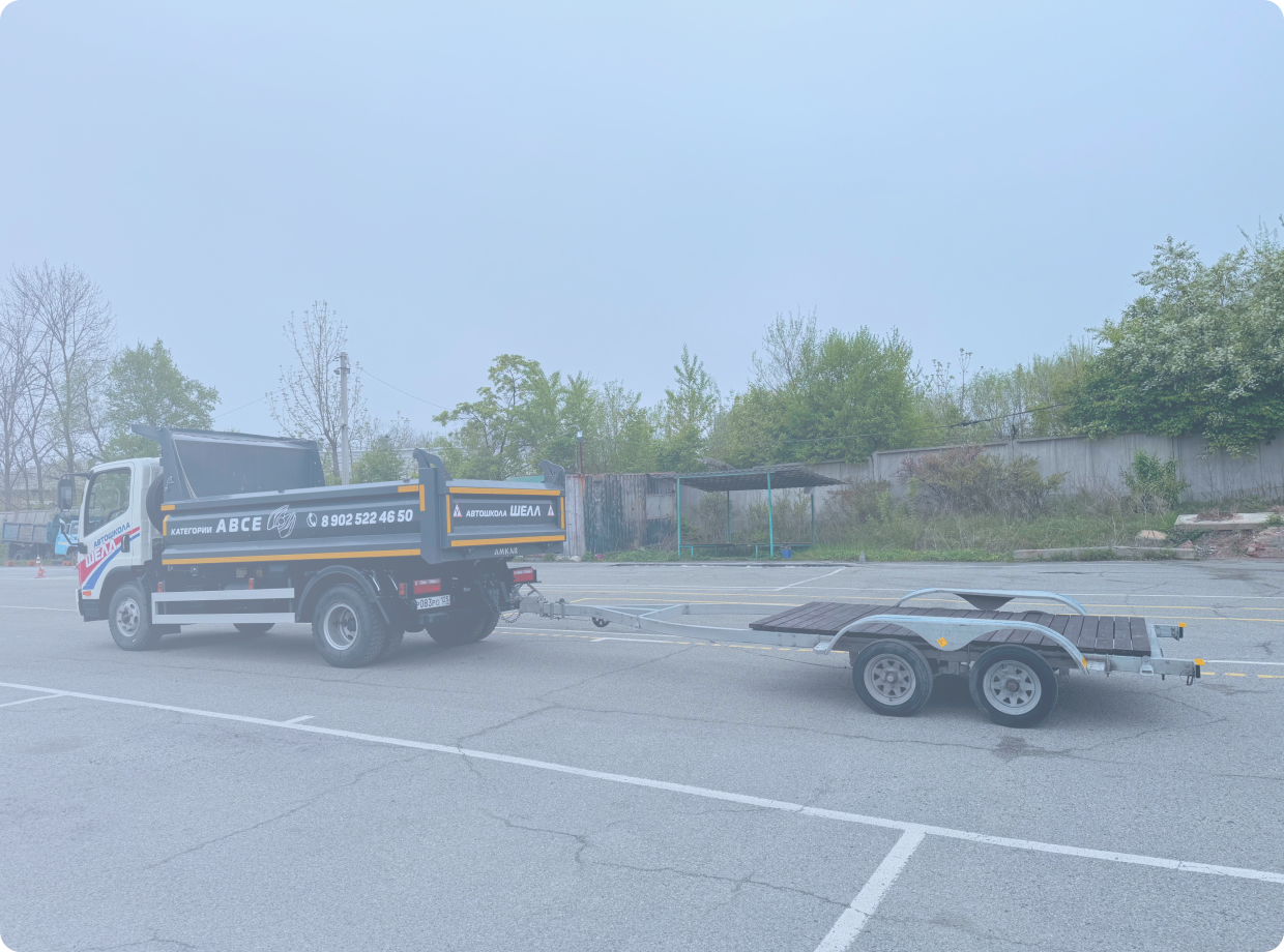 Черно-бронзовый мотоцикл стоит на стоянке у серого бетонного здания, вид сбоку