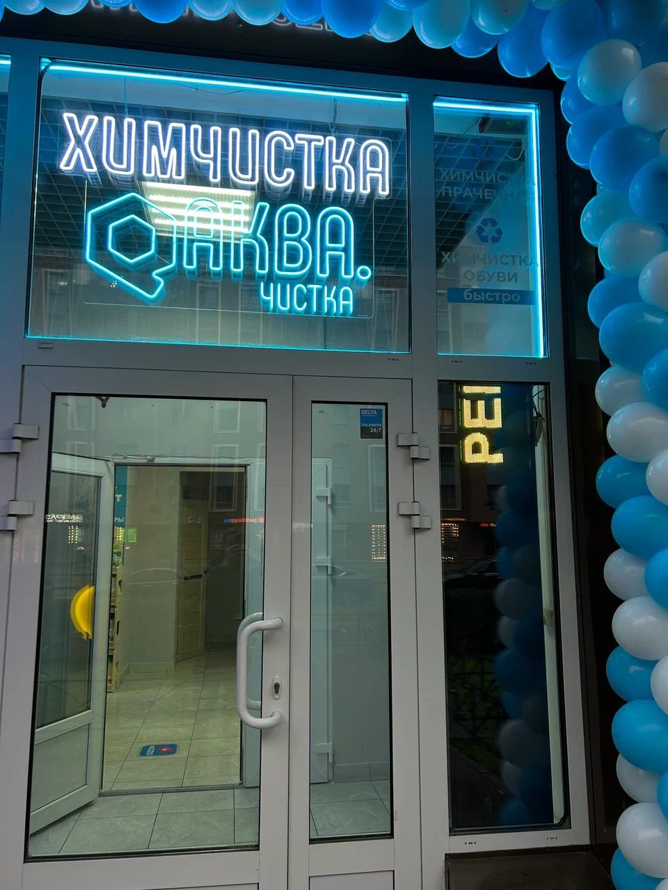 Неоновая надпись «Химчистка» и логотип Аква.Чистка над дверью