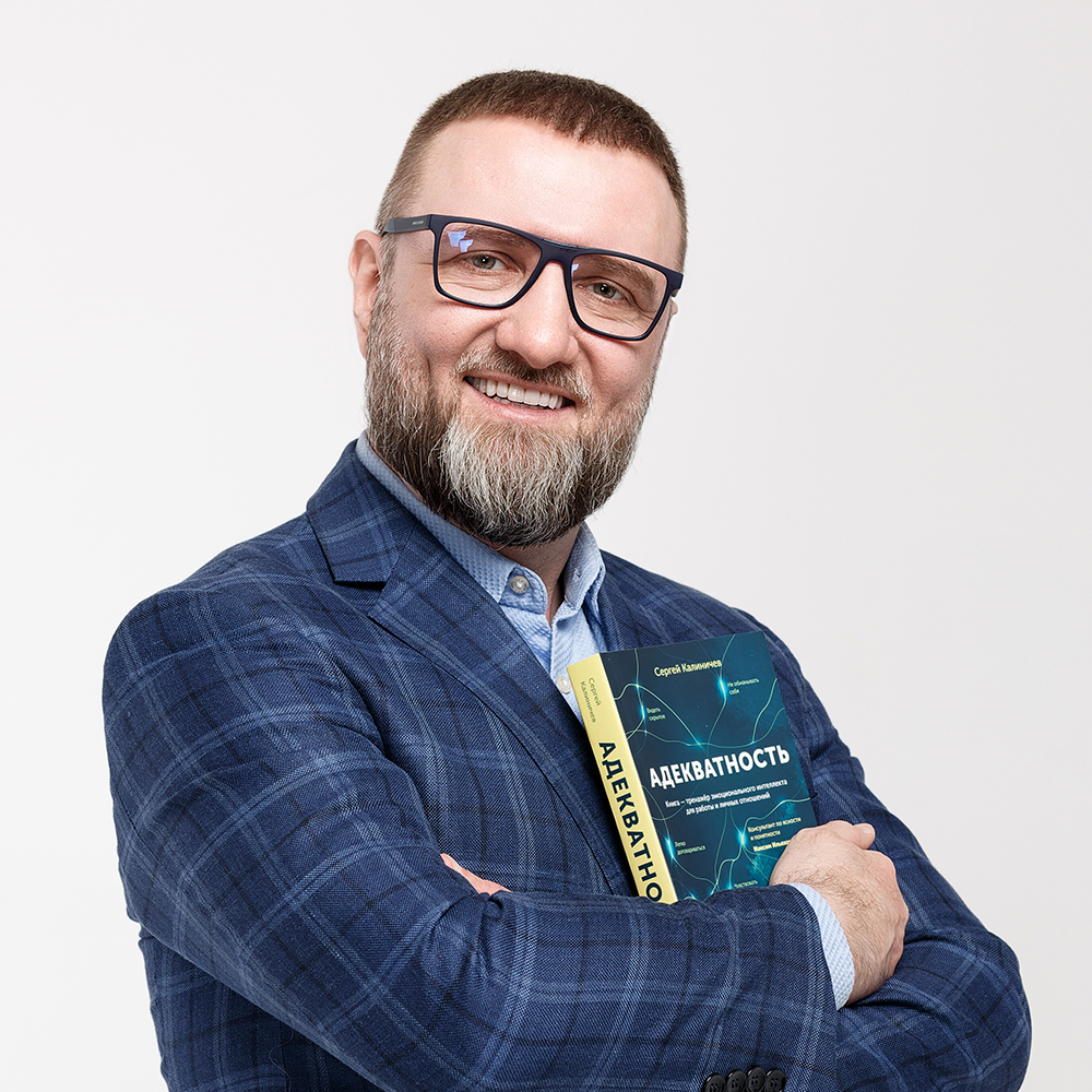 Сергей Калиничев держит книгу «Адекватность», название хорошо видно на обложке