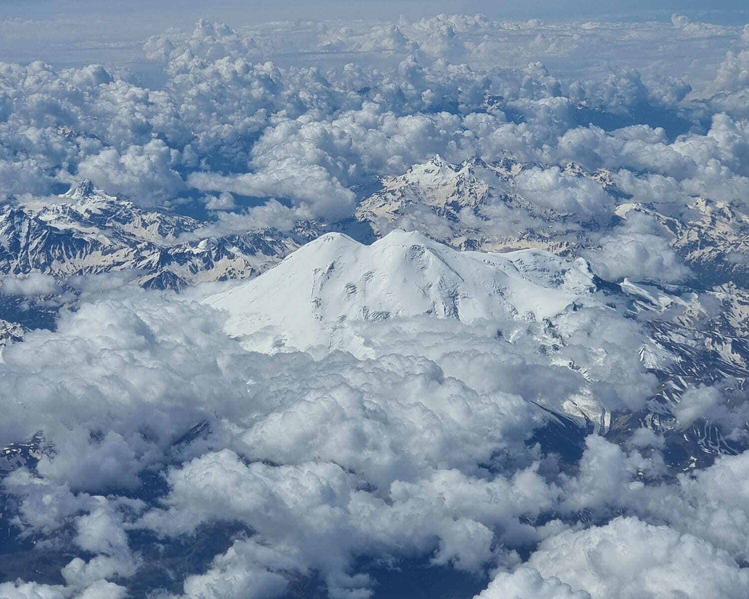 Aerial view of the twin summits of Elbrus rising above a sea of clouds