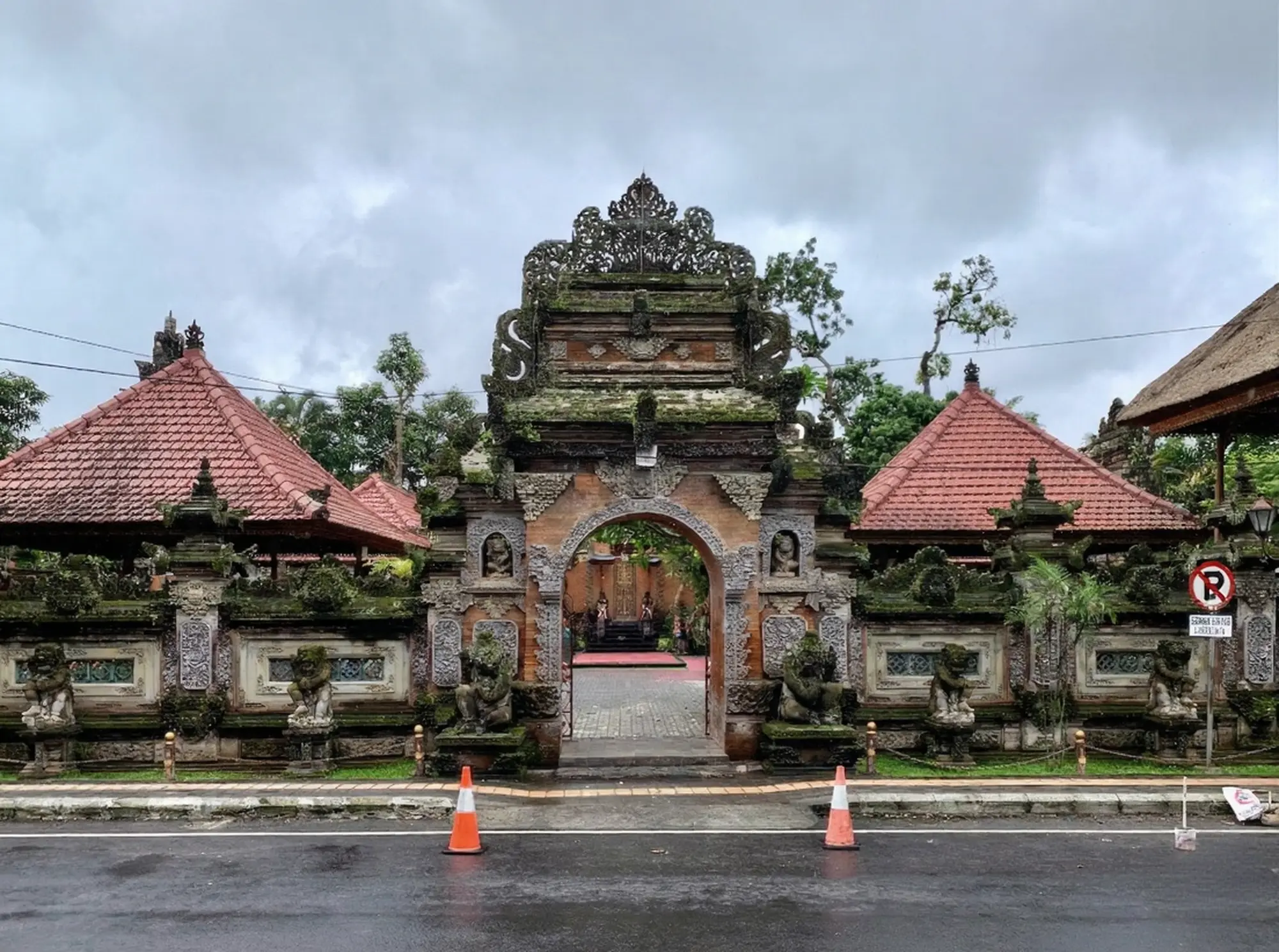 The stunning traditional Balinese architecture and intricate stone carvings of the Ubud Royal Palace gates, located directly across the street from the Ubud Art Market.