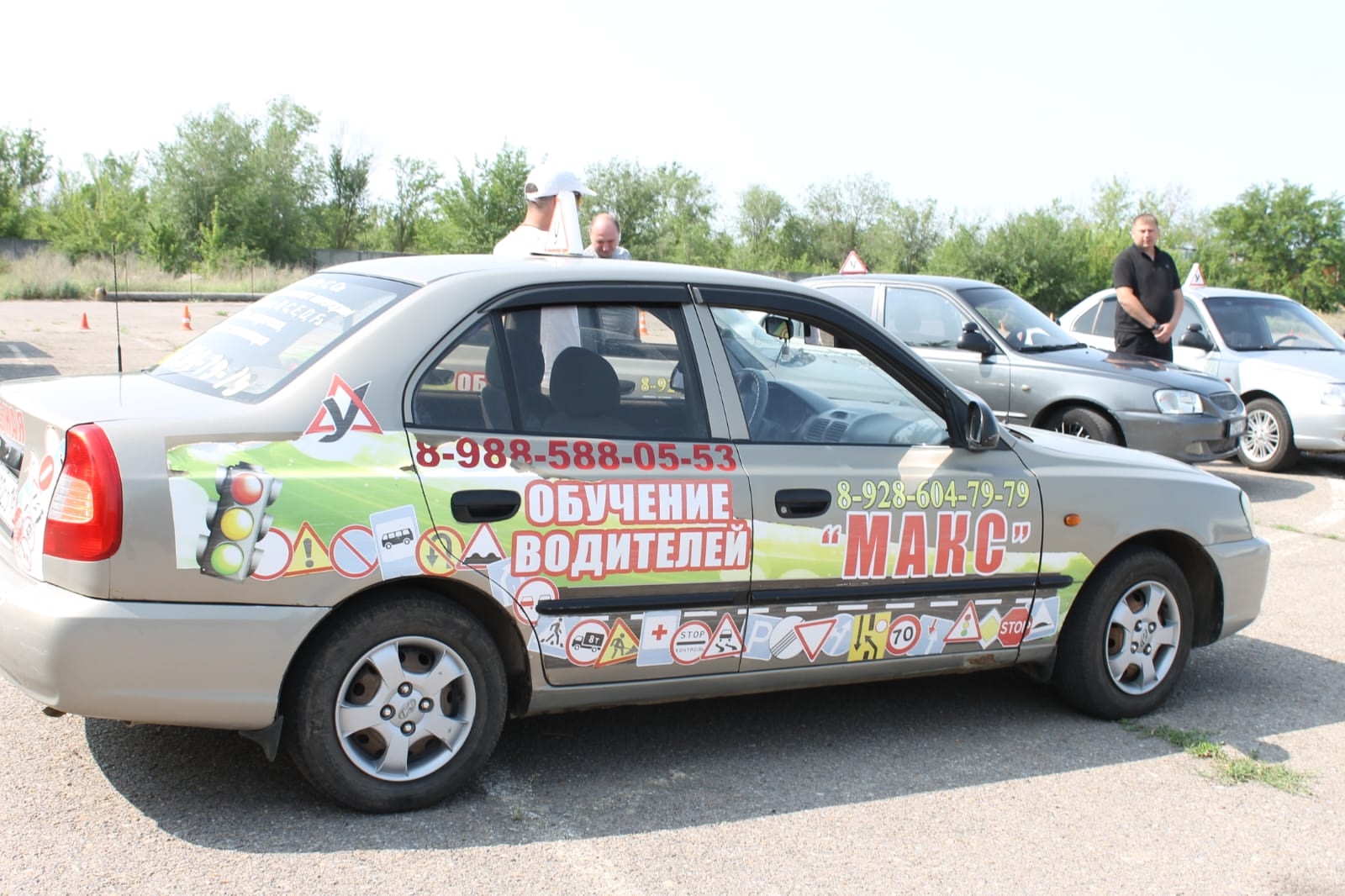 Учебный автомобиль автошколы «Макс» рядом с инструкторами
