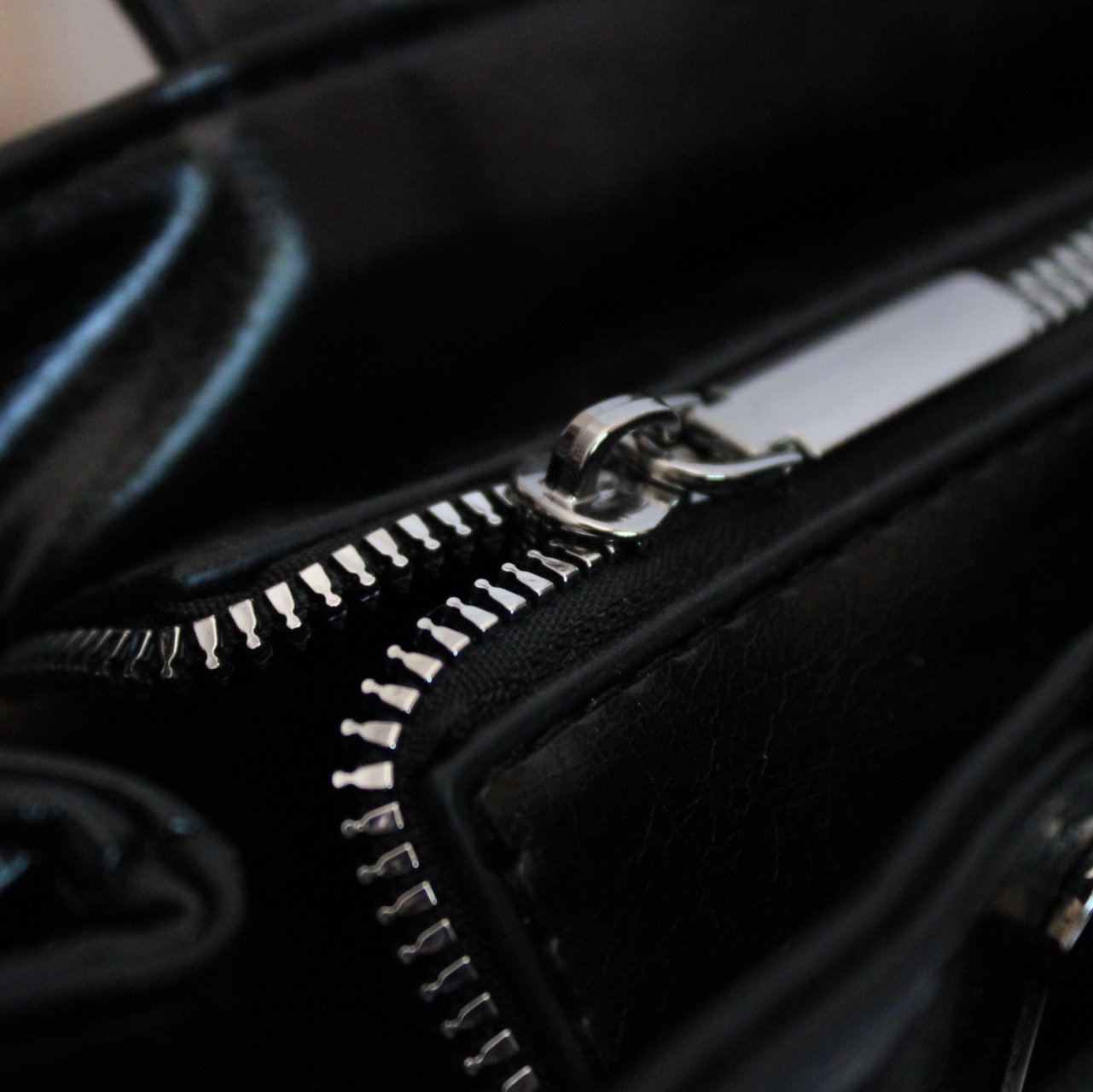 Купить сумку-багет черного цвета с серебристой фурнитурой и ремнем.