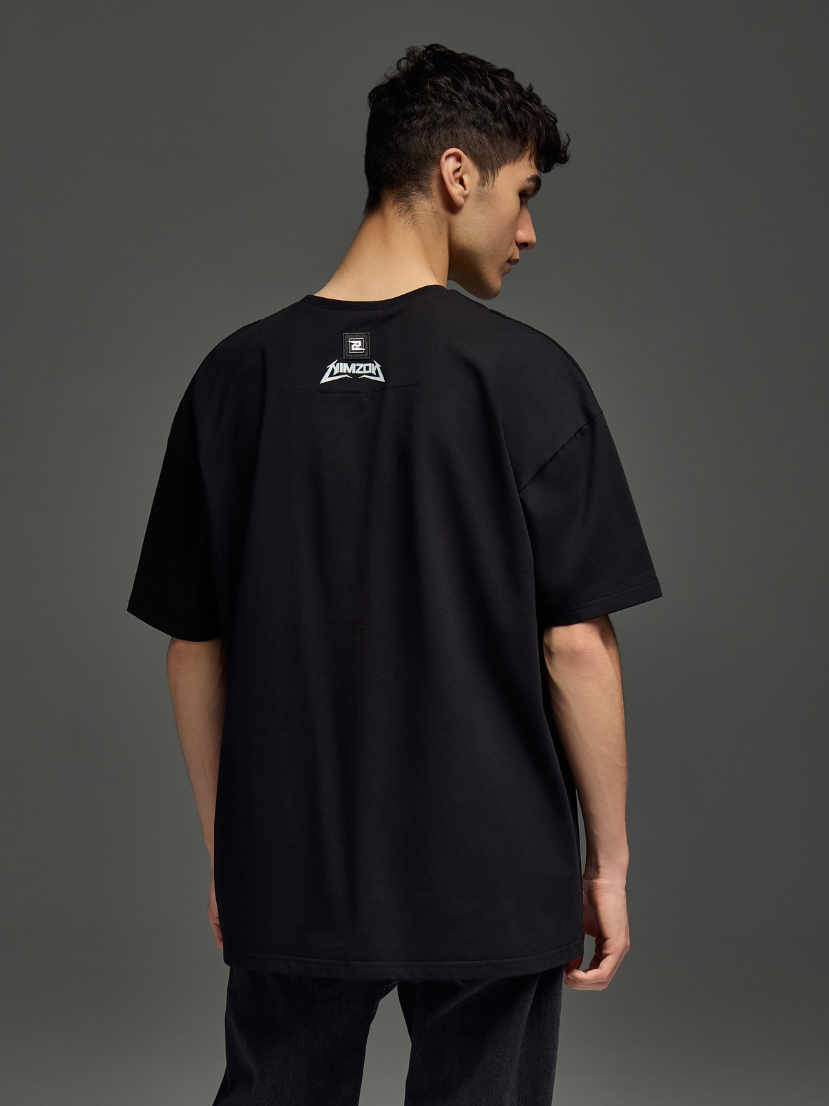 мужчина в черной футболке на нейтральном фоне