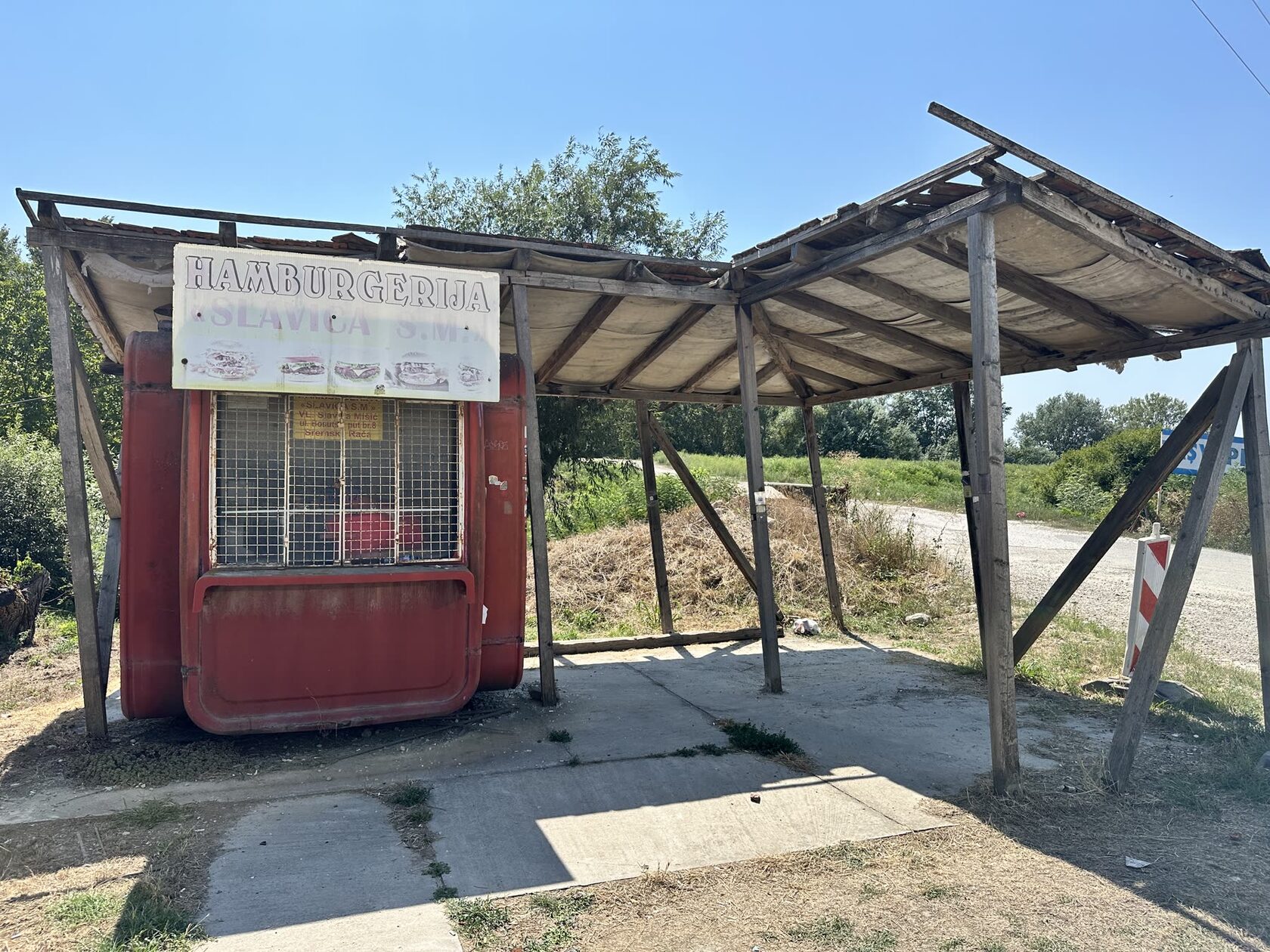 The real abandoned K67 kiosk and wooden pavilion at the Sremska Raca visa-run waiting zone