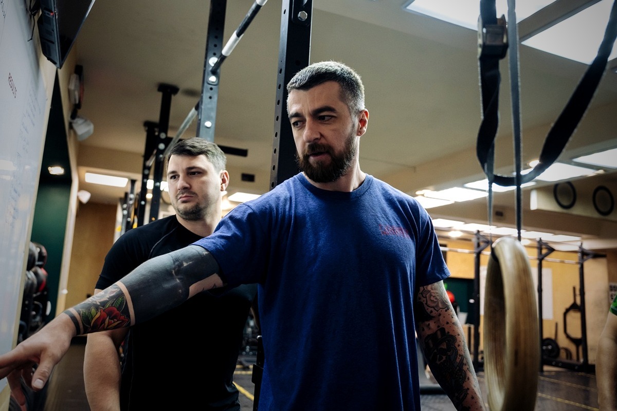 Тренер объясняет технику участнику в CrossFit Center Rostov