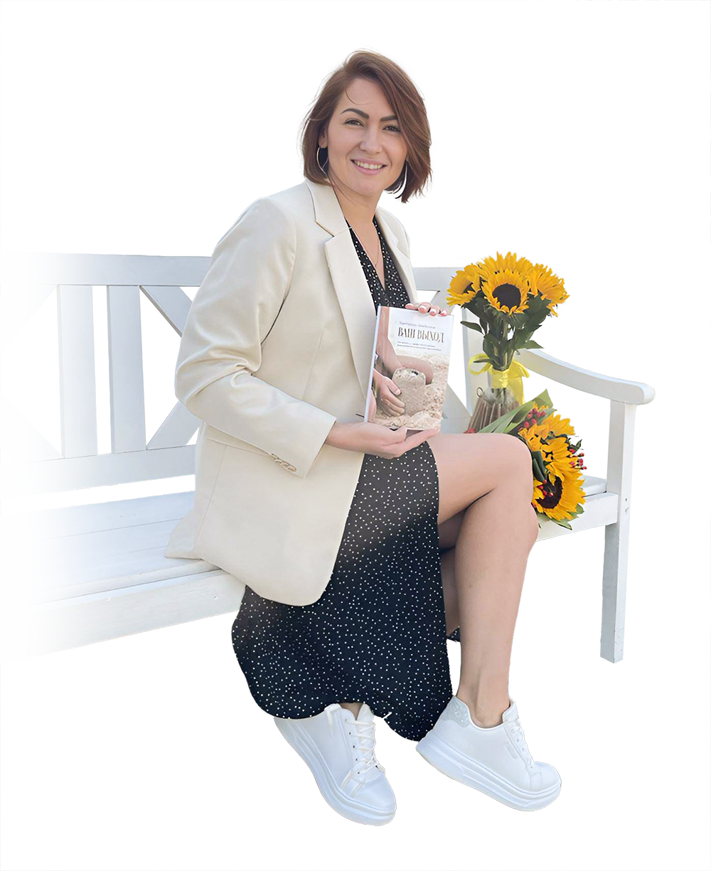 Автор книги «Ваш выход» сидите кресле и держит свою изданную книгу и улыбается