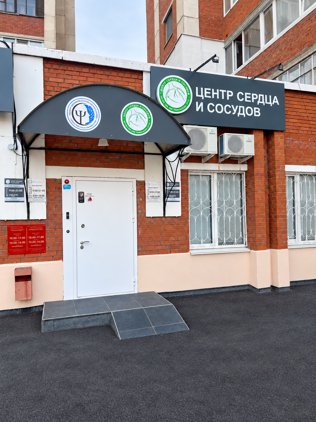 Вход в Центр сердца и сосудов в Уфе: белая дверь под тёмным козырьком и вывеска центра