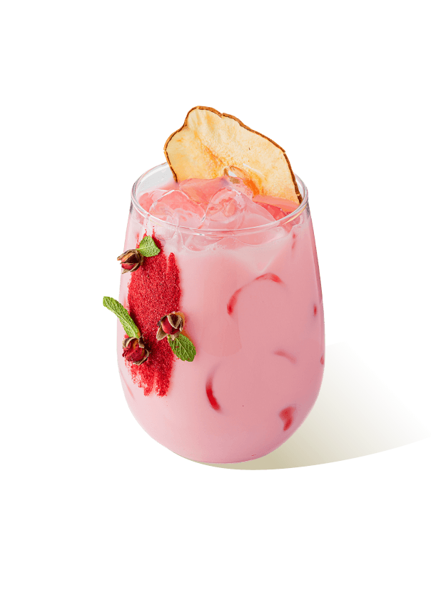 Pink iced drink with sugar syrup, apple slice garnish and rosebuds, prepared using The Base Beverage syrup for cafes and mixology