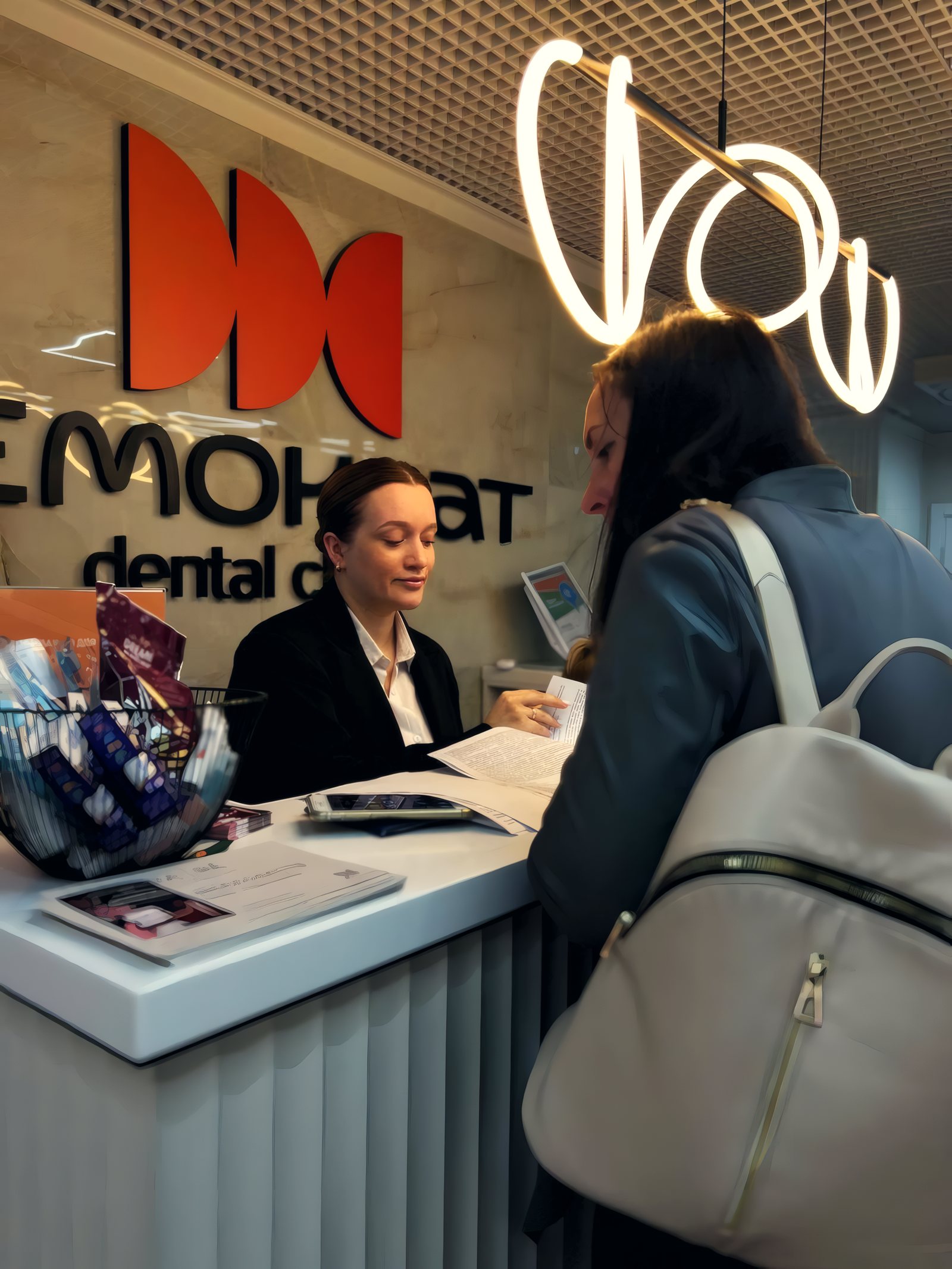 Администратор клиники Demokrat принимает пациента на ресепшене
