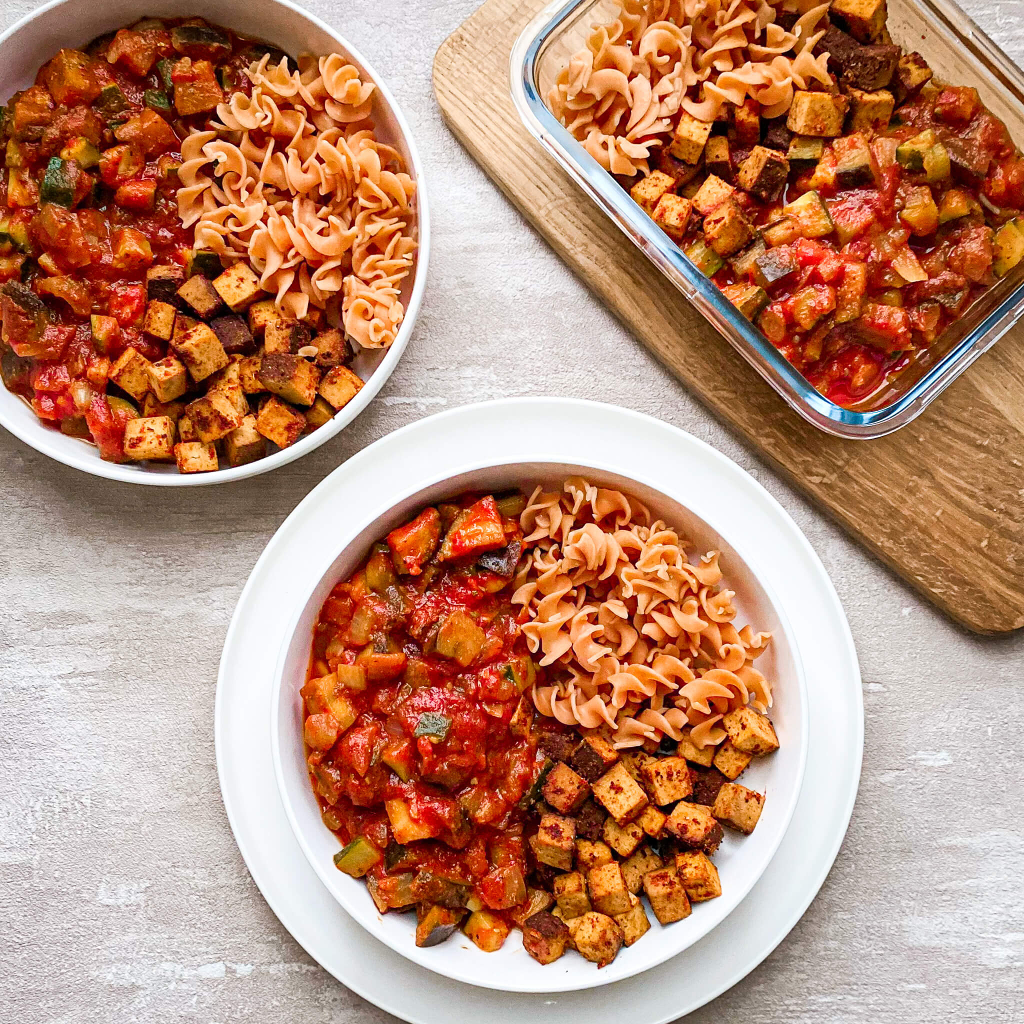 Ratatouille mit Räuchertofu angerichtet in Teller, Schüssel und Auflaufform
