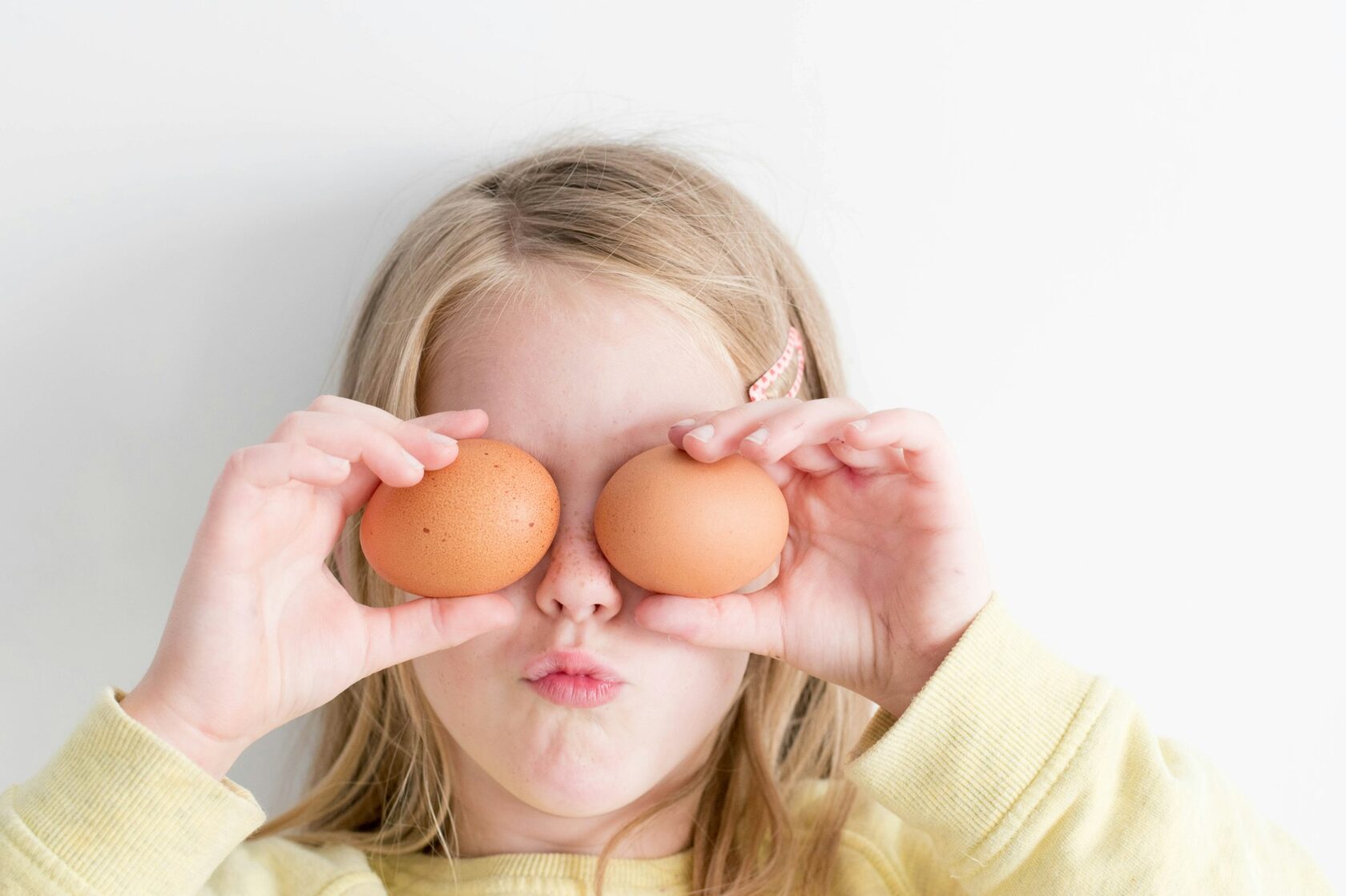 child holding eggs to their eyes