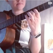 ученик по акустической гитаре играет с репетитором на онлайн уроке