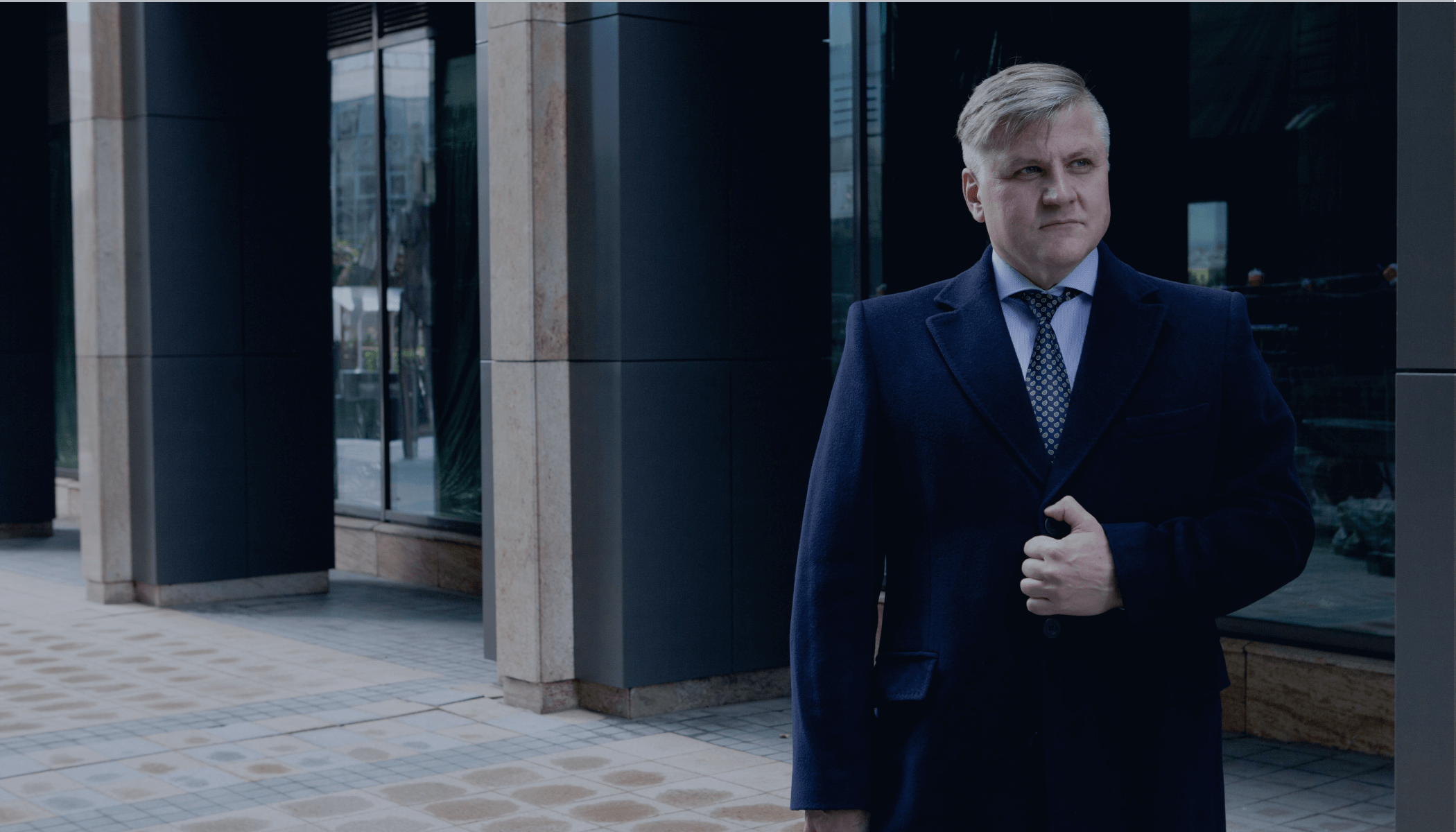 Мужчина в синем костюме на фоне офиса. Юридические услуги