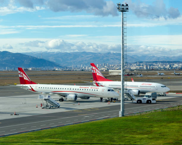 Самолеты Georgian Airways в аэропорту Тбилиси на фоне гор и телевышки Мтацминда — идеальное начало релокации в Грузию с Flip Flat