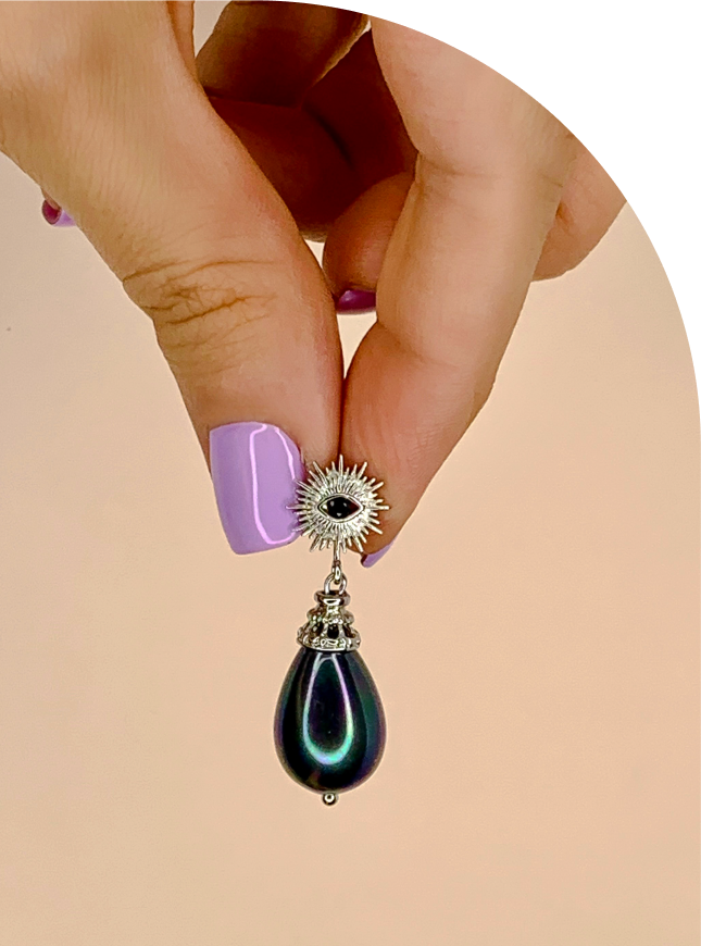 рука держащая Серьги с всевидящим оком и чёрным жемчугом