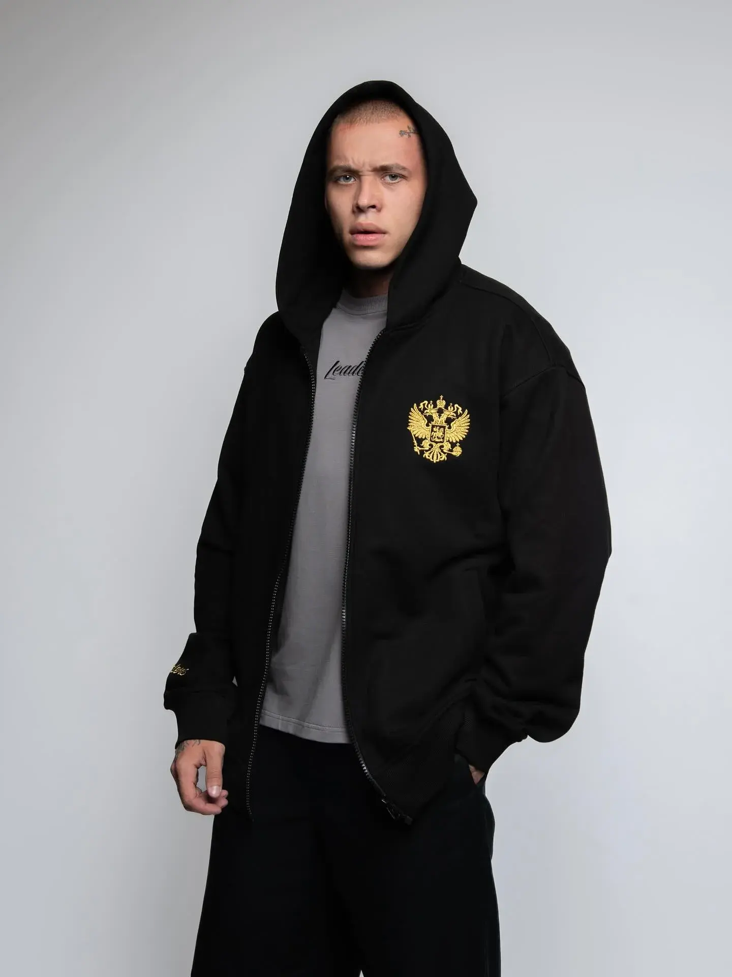 Модель в чёрном худи Leaders Wear с гербом России.