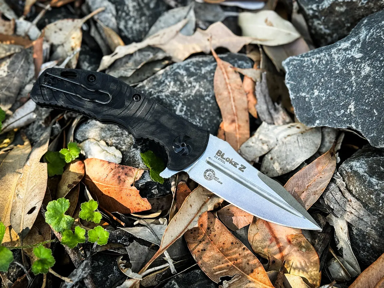 Kizlyar Supreme Bloke Z folding knife on forest rocks