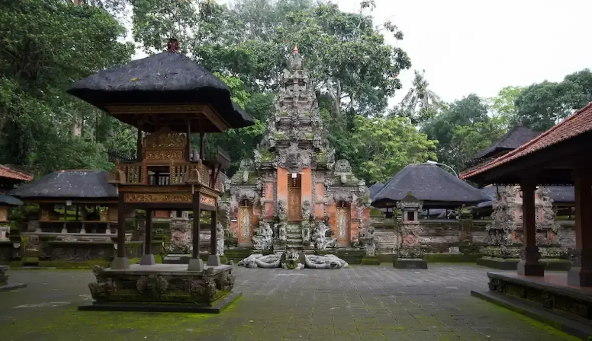 The stunning temple courtyard, intricate stone carvings, and traditional thatched roofs of Pura Dalem Agung Padangtegal, the main spiritual hub of Monkey Forest Ubud.