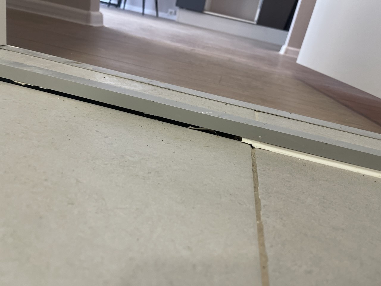 Не до конца выполнена герметизация между дверным порогом и напольной плиткой