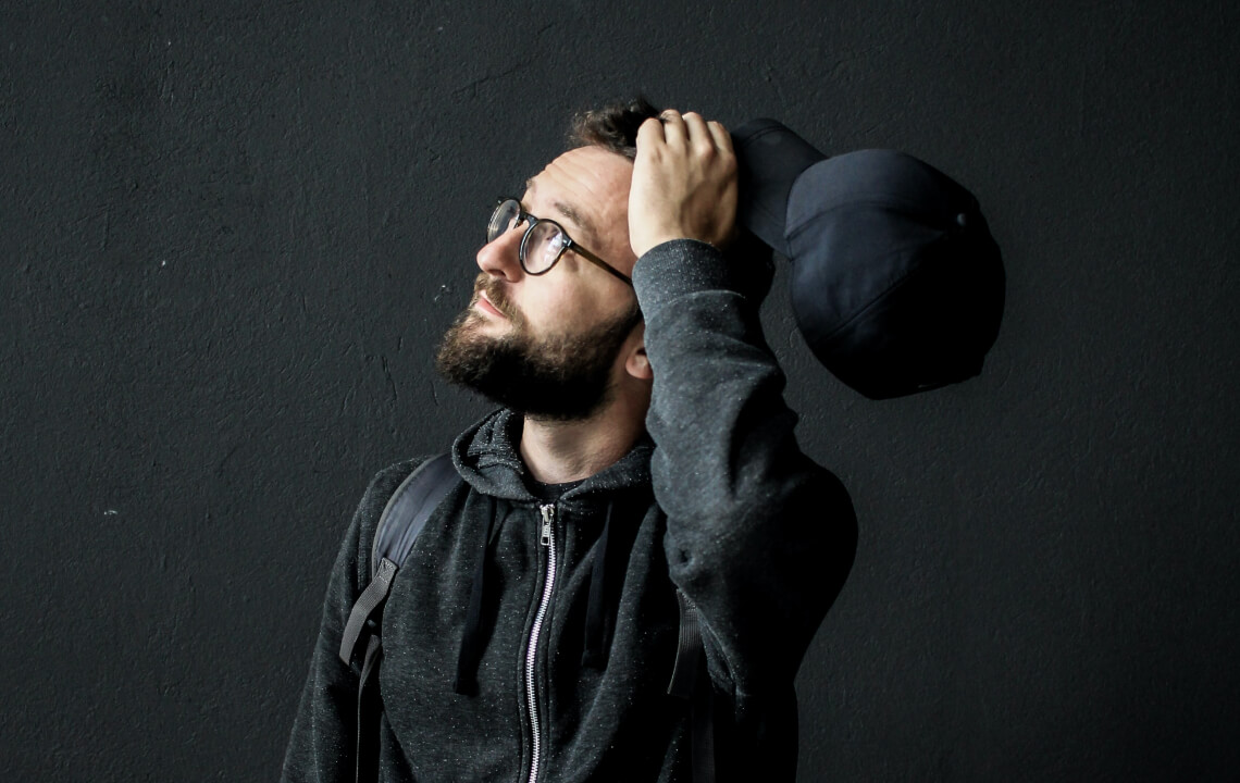 мужчина с бородой держится за голову