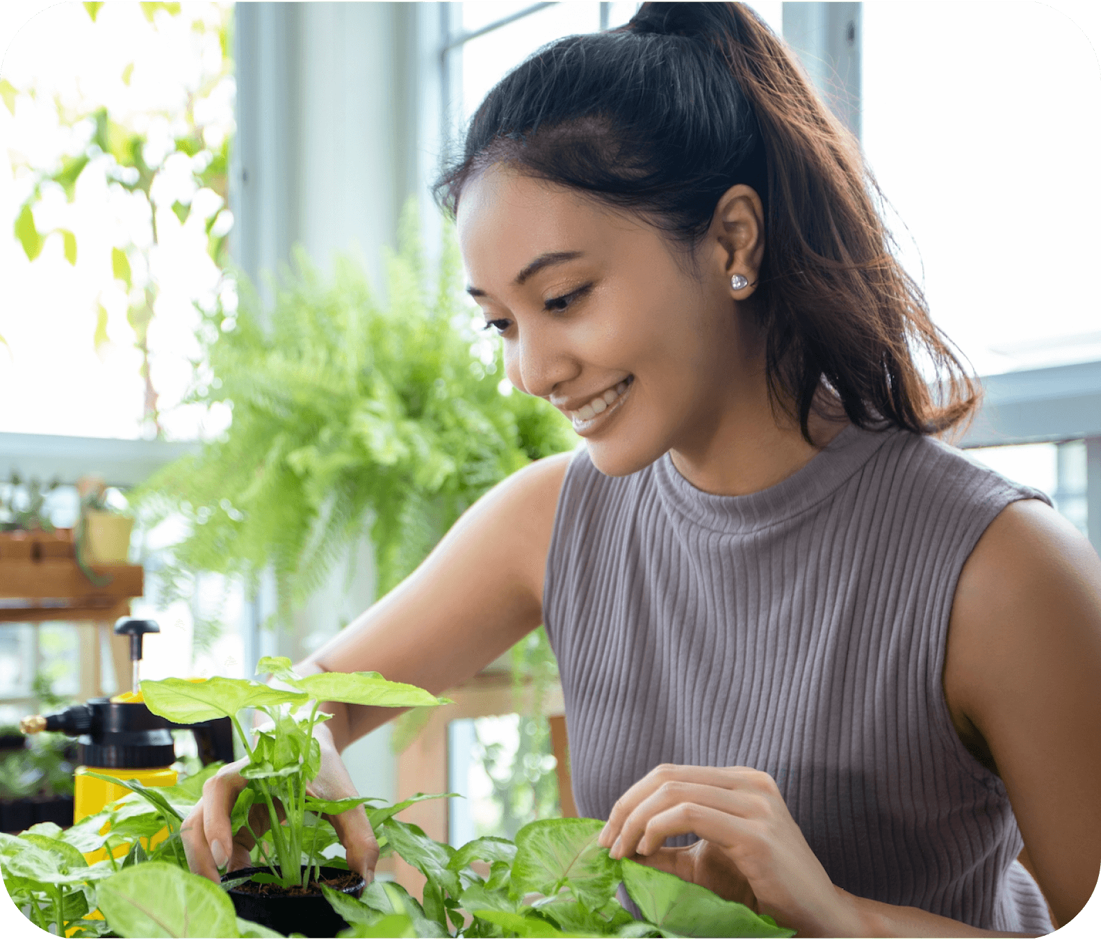 Девушка улыбается и смотрит на домашние растения