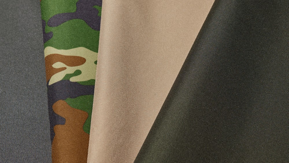 Образцы различных тентовых тканей камуфляжной бежевой и зеленой расцветки с видимой структурой плетения для выбора материала под конкретные задачи