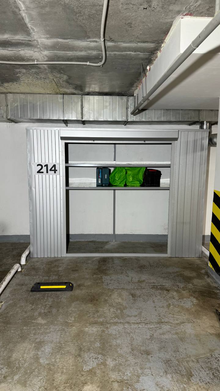 Роллетный шкаф в паркинг (MaxParking) серебристого цвета с металлическими полками для хранения колес и велосипедов.