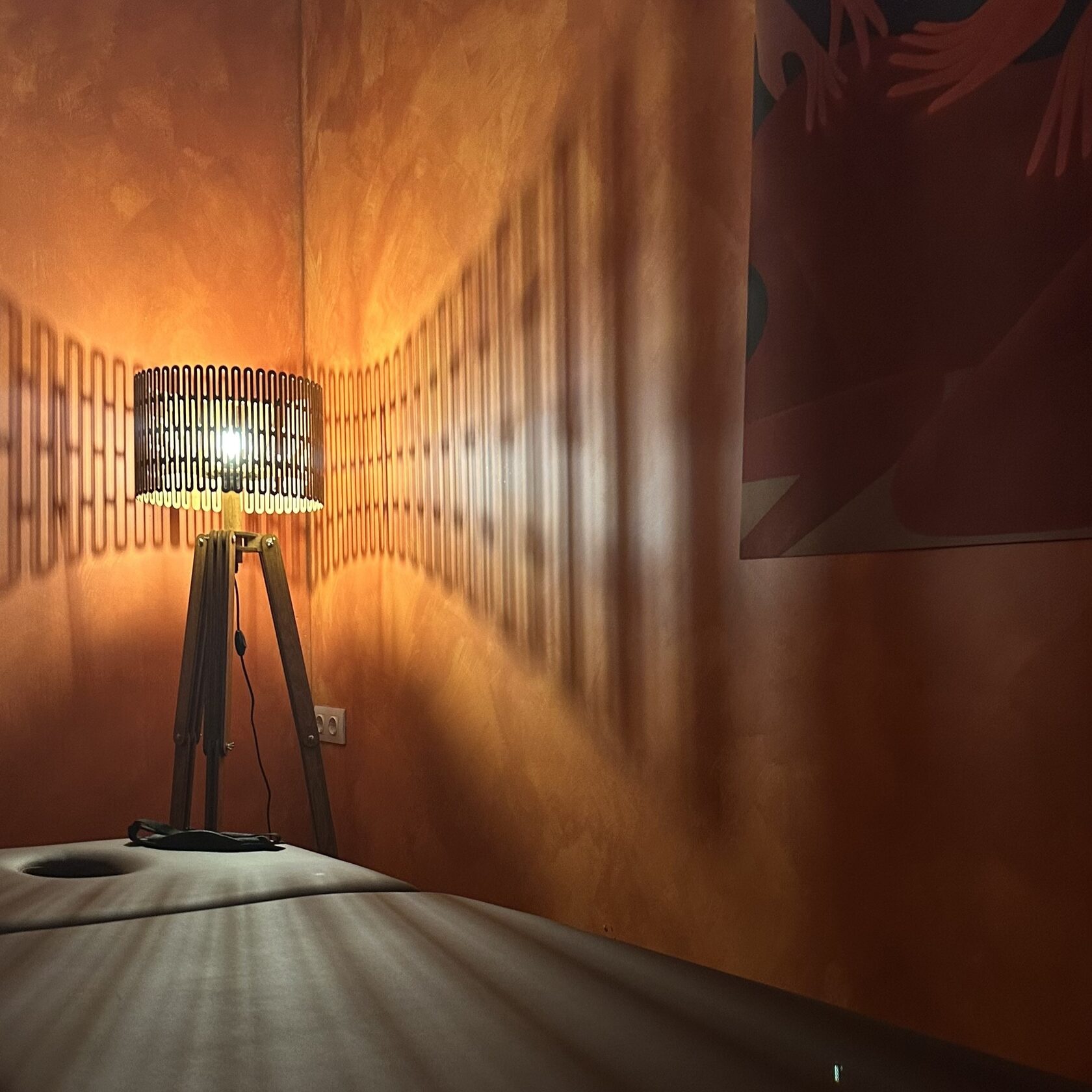 Интерьер массажной комнаты студии ПАУЗА в Москве. Премиальный массажный стол, дизайнерский торшер и арт-постер создают атмосферу полного релакса.