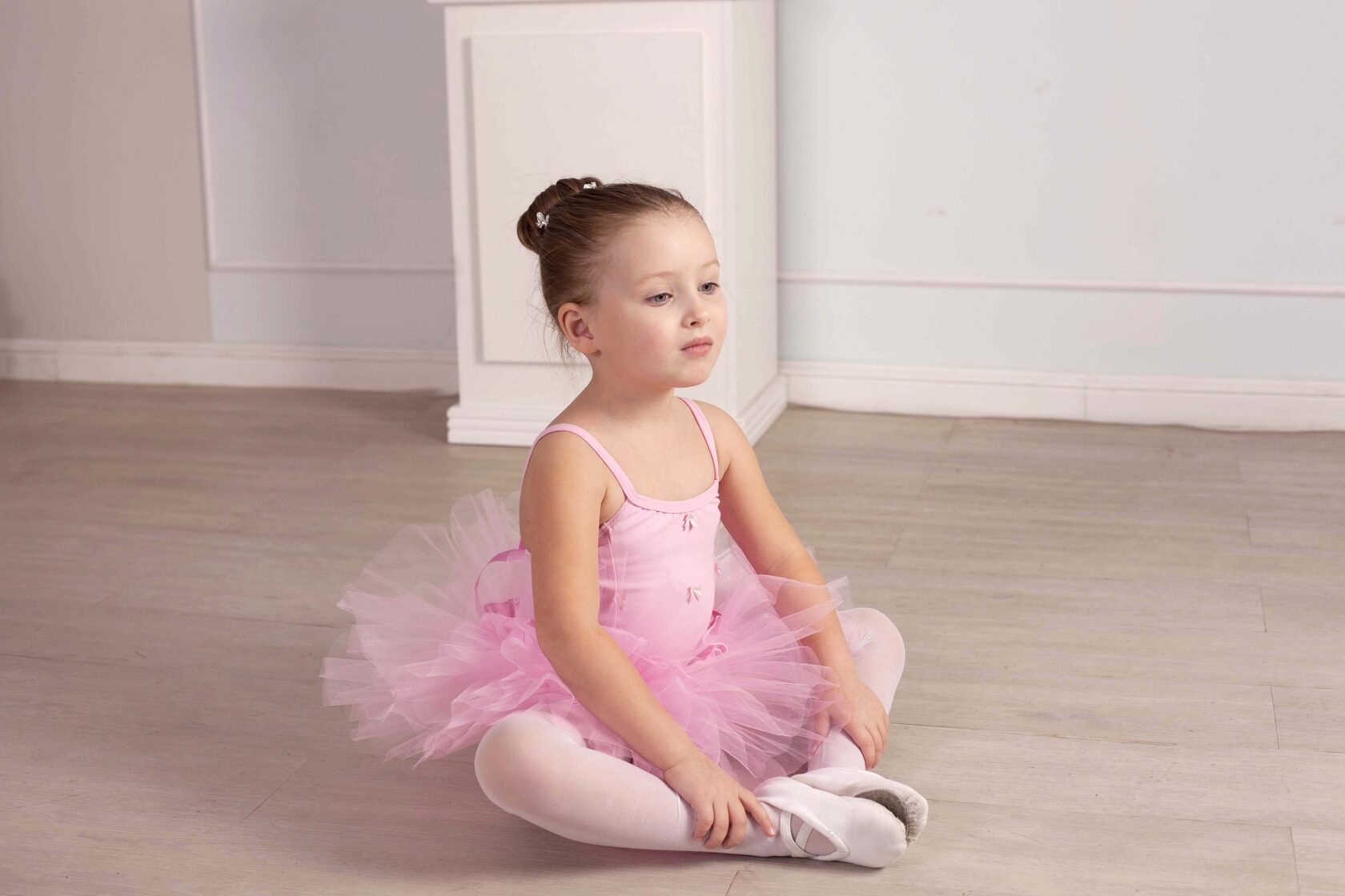 Девочка в розовой пачке сидит в бабочке