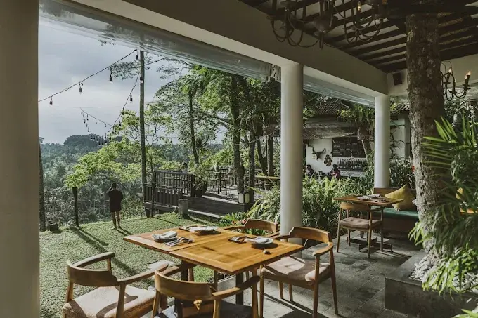 A breathtaking open-air terrace perfect for a top dinner in Ubud, offering diners stunning daytime and sunset views over a vast, lush green jungle canyon.
