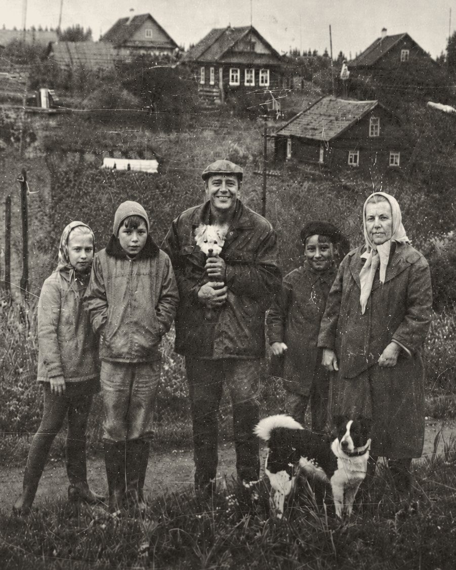 Архивная фотография: семья с собаками на фоне деревни