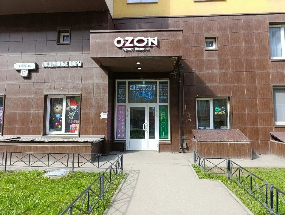 Вход под козырьком OZON с неоновой вывеской «Химчистка Аква.Чистка», проспект Ветеранов, 171 к5